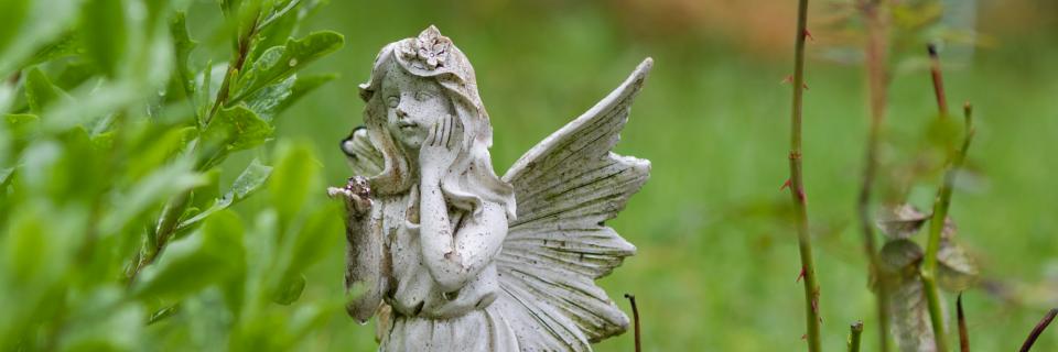 Symbolbild: Engelfigur sitzt im Gras