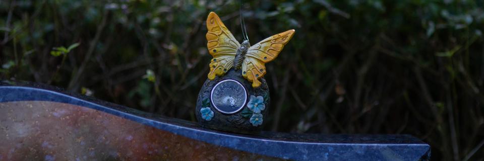 Symbolbild: Schmetterling auf Grabstein